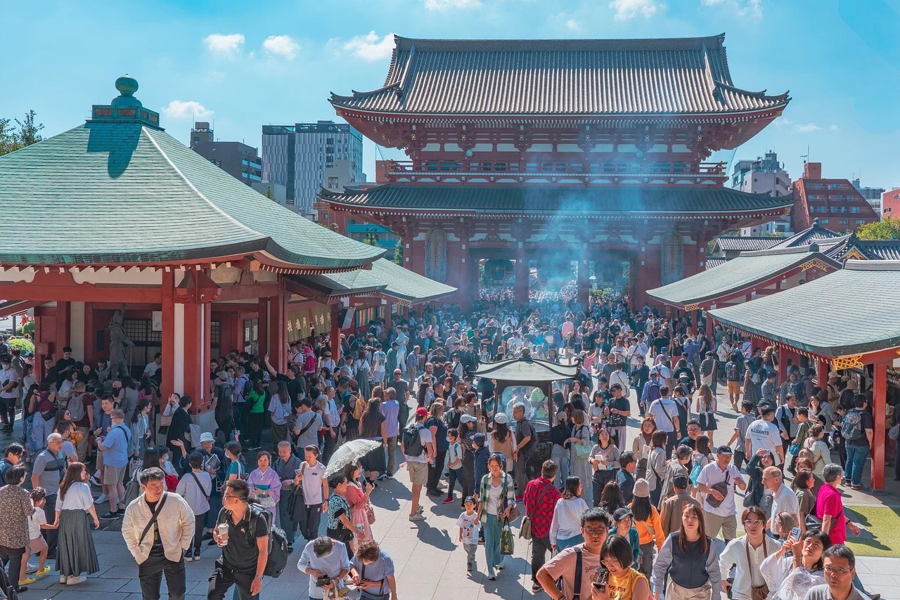 東京の浅草寺にある宝蔵門と、参拝客や観光客で賑わう境内の様子。