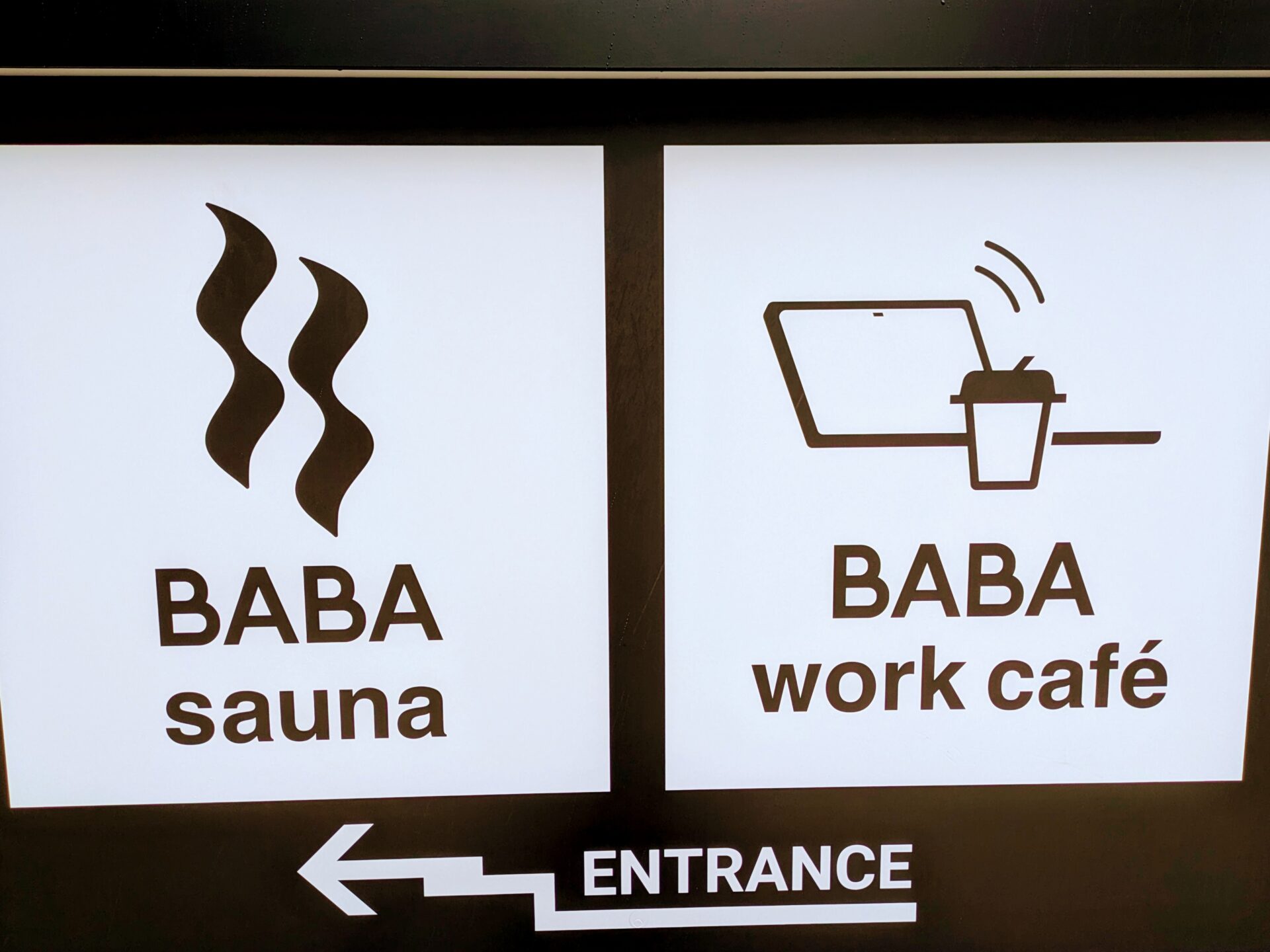 BABA saunaとBABA work cafeの入り口を示す看板。左はサウナ、右はノートPCとコーヒーのイラストでワークカフェを表している。
