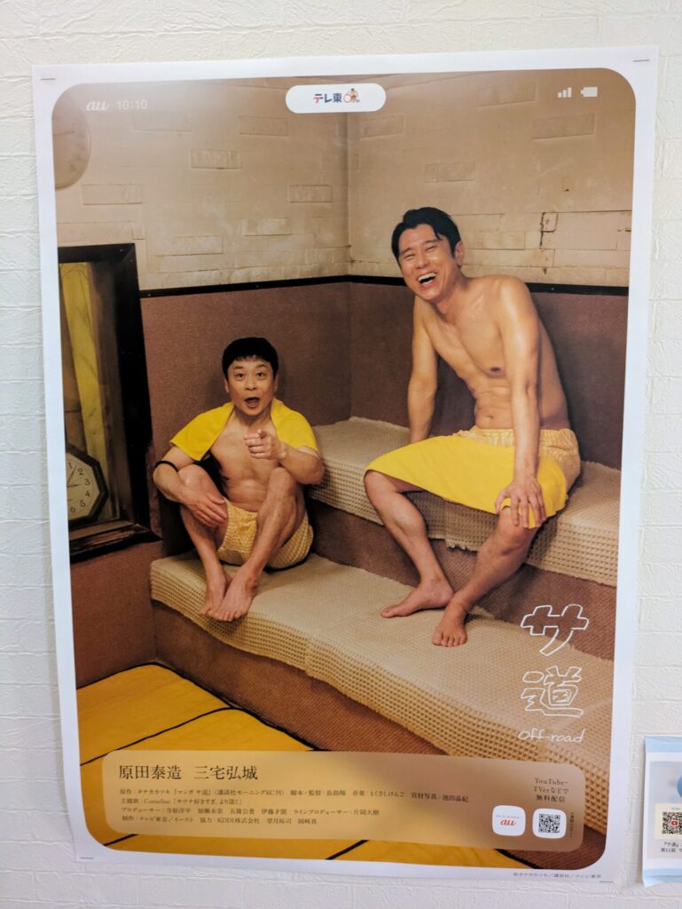 俳優の原田泰造と三宅弘城が出演する「サ道」のポスター。2人がサウナ室で笑顔を見せながら座っており、背景にはサウナの内部や時計が見える。ポスターの下部には出演者や番組情報が記載されている。