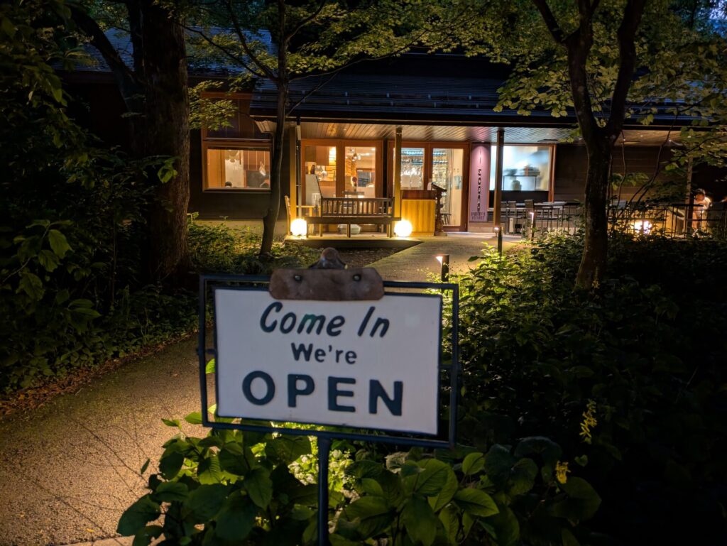 ハルニレテラスのilsognoの入り口。温かい光が漏れる夜の特別なカフェ。