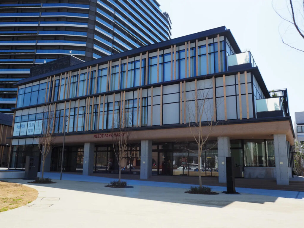 明治公園に新しくできた商業施設「MEIJI PARK MARKET」の外観。広々としたエントランスと近代的なデザインが特徴。